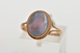 A 9CT GOLD OPAL RING, of an oval design, set with an opal cabochon, displaying blue and red play