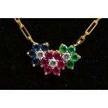 A YELLOW METAL GEMSTONE PENDANT NECKLACE, the pendant in the form of three flowers, with rubies,