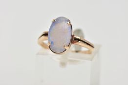 A YELLOW METAL OPAL RING, designed with a four claw set oval opal cabochon, bifurcated shoulders