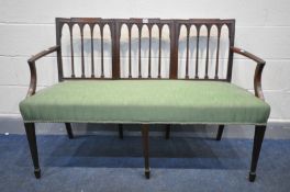 AN EARLY 20TH CENTURY MAHOGANY SOFA, with shaped spindled back, and open armrests, on square tapered