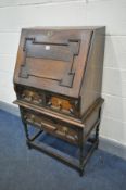 AN EARLY 20TH CENTURY OAK BUREAU, with a geometric design, fitted interior and two drawers, width