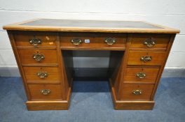 AN EARLY 20TH CENTURY OAK KNEE HOLE DESK, with a black leatherette skiver top, canted front corners,