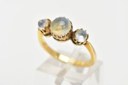 A YELLOW METAL MOONSTONE RING, designed with a central circular cut moonstone and flanked with two