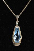 A PENDANT NECKLACE, the pendant of an art deco style set with a light blue fancy cut stone