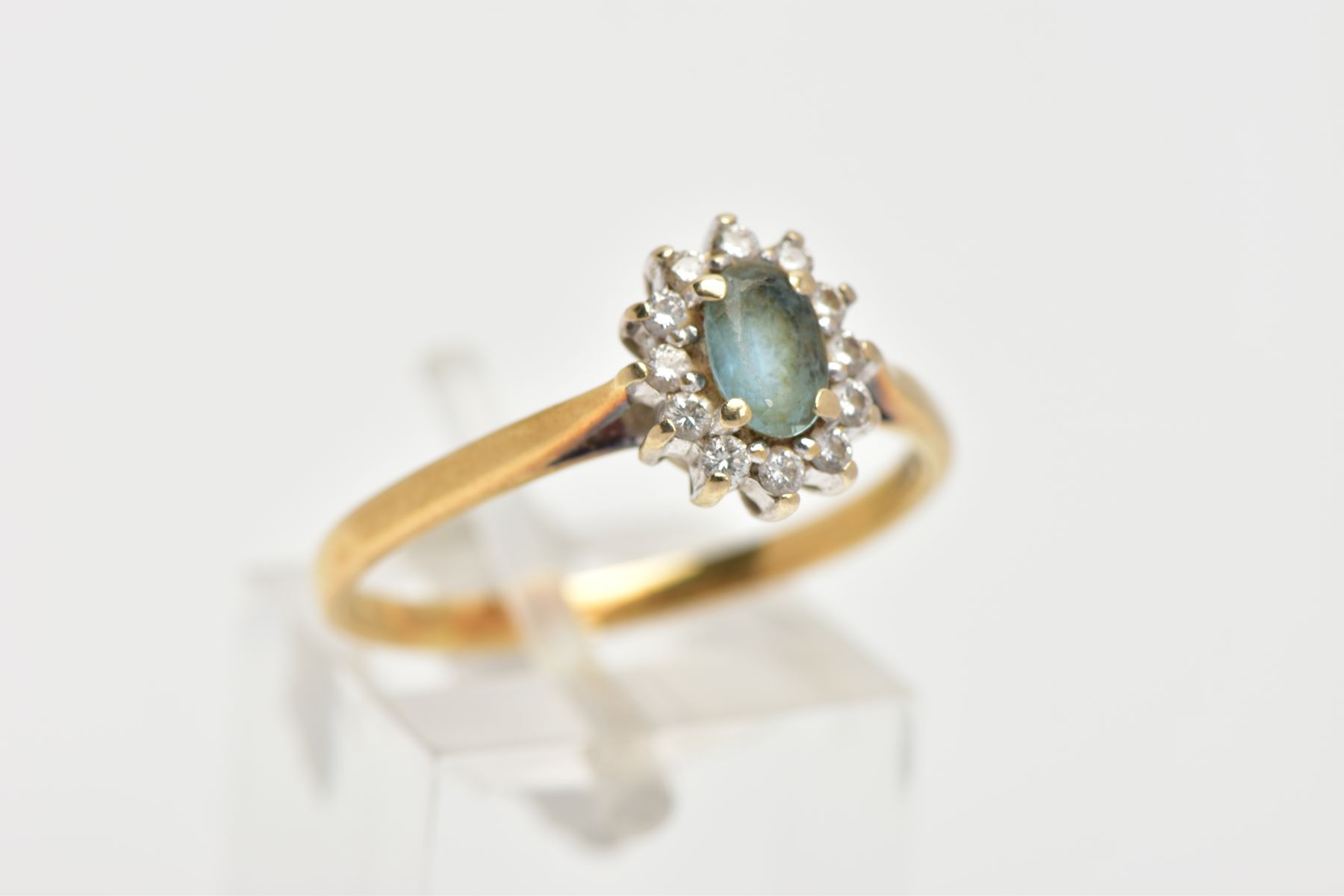 AN 18CT GOLD GEM SET CLUSTER RING, of an oval form, centring on an oval cut aquamarine, within a - Image 4 of 4