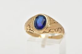 A 9CT GOLD SIGNET RING, of an oval design, set with an oval cut blue stone assessed as paste,