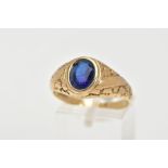 A 9CT GOLD SIGNET RING, of an oval design, set with an oval cut blue stone assessed as paste,