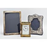 TWO SILVER PHOTO FRAMES AND A CARRIAGE CLOCK, the first frame featuring a floral design and an