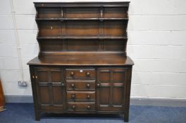 A DARK ERCOL ELM OLD COLONIAL DRESSER, with plate rack to top, base with two cupboard doors flanking