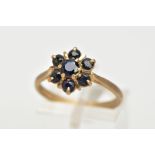 A 9CT GOLD SAPPHIRE CLUSTER RING, seven circular cut sapphires prong set in a floral design, leading