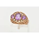 AN AMETHYST AND SEED PEARL DRESS RING, three stone ring set with a central oval cut amethyst flanked