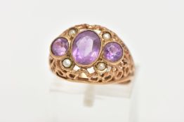 AN AMETHYST AND SEED PEARL DRESS RING, three stone ring set with a central oval cut amethyst flanked