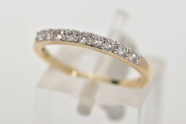 A 9CT GOLD DIAMOND HALF ETERNITY RING, designed with a row of nine claw set round brilliant cut