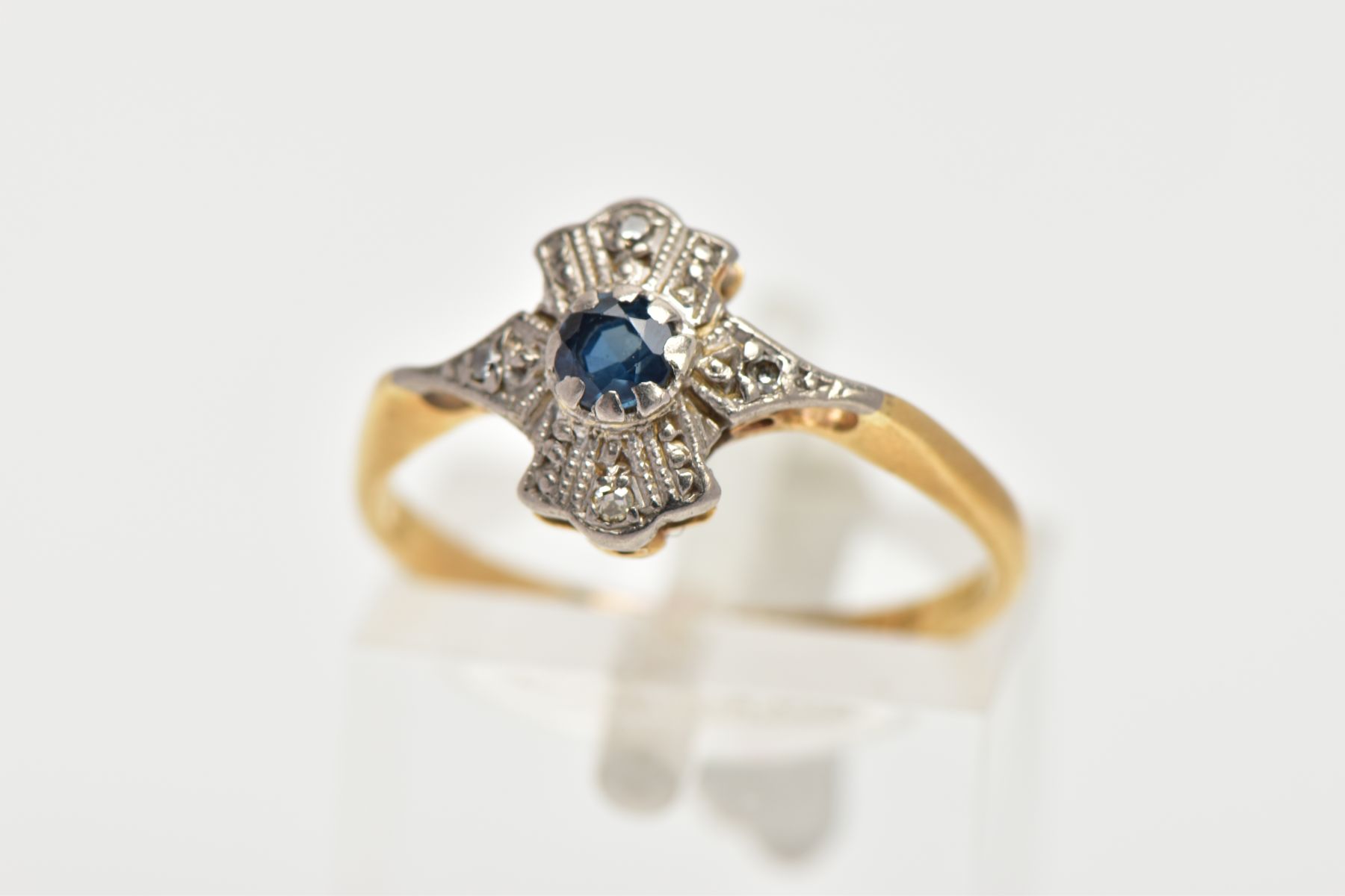 A 18CT GOLD SAPPHIRE AND DIAMOND RING, a circular cut blue sapphire set in an art deco style white