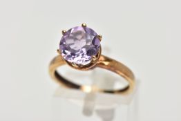 A AMETHYST SOLITAIRE RING, a circular cut amethyst, approximate diameter 9mm, set in a yellow