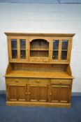 A LARGE PINE DRESSER, the top section with four glazed doors flanking and open shelf section and