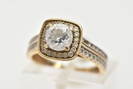 A 9CT GOLD CUBIC ZIRCONIA RING, a circular cut cubic zirconia, set within a squared halo of circular