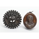 A JET BROOCH AND A VULCANITE PENDANT, the jet brooch of a circular form, decorated with carved