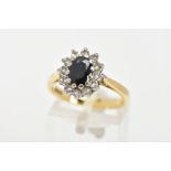 A SAPPHIRE AND DIAMOND CLUSTER RING, a blue oval sapphire prong set with twelve round brilliant