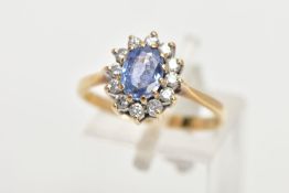 A 9CT GOLD SAPPHIRE AND DIAMOND RING, oval cut sapphire set with a halo of round brilliant diamonds,