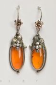 A PAIR OF SILVER AND AMBER EARRINGS, elongated oval amber set into floral and foliage silver mounts,
