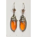 A PAIR OF SILVER AND AMBER EARRINGS, elongated oval amber set into floral and foliage silver mounts,