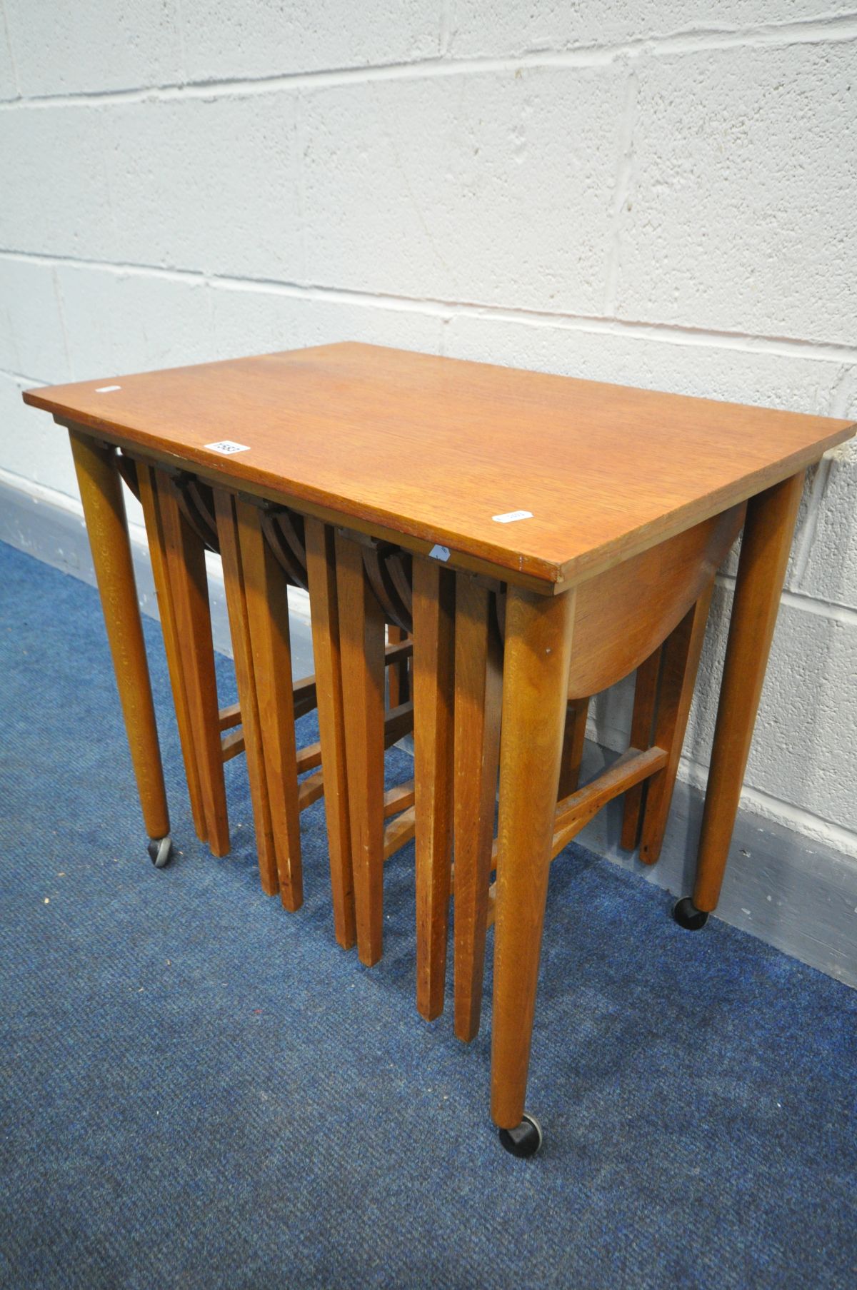 IN THE MANNER OF POUL HUNDEVAD, a mid-century teak nesting tables, with four circular drop leaf - Image 2 of 3