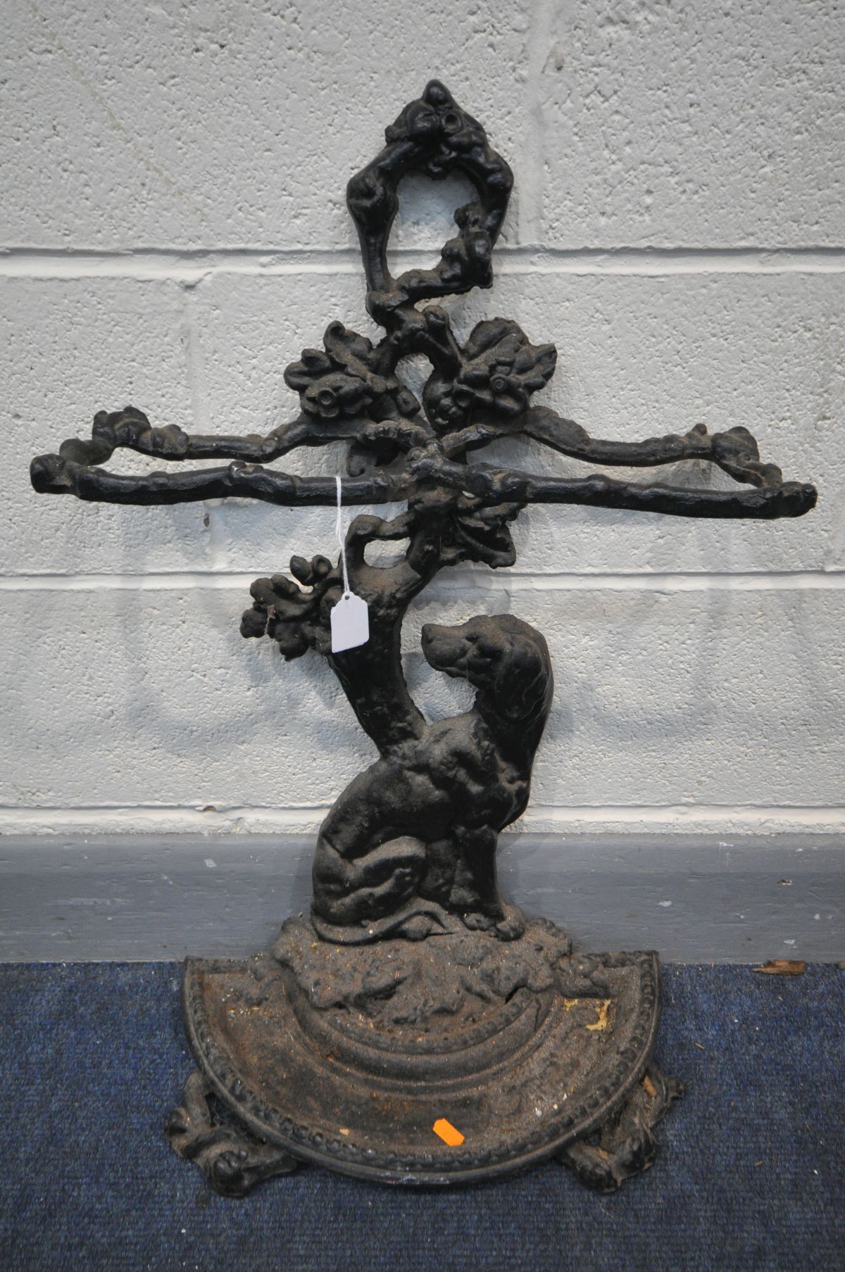 A CAST IRON UMBRELLA STAND, with a seated dog as the upright, with a removable oval tray, width 31cm
