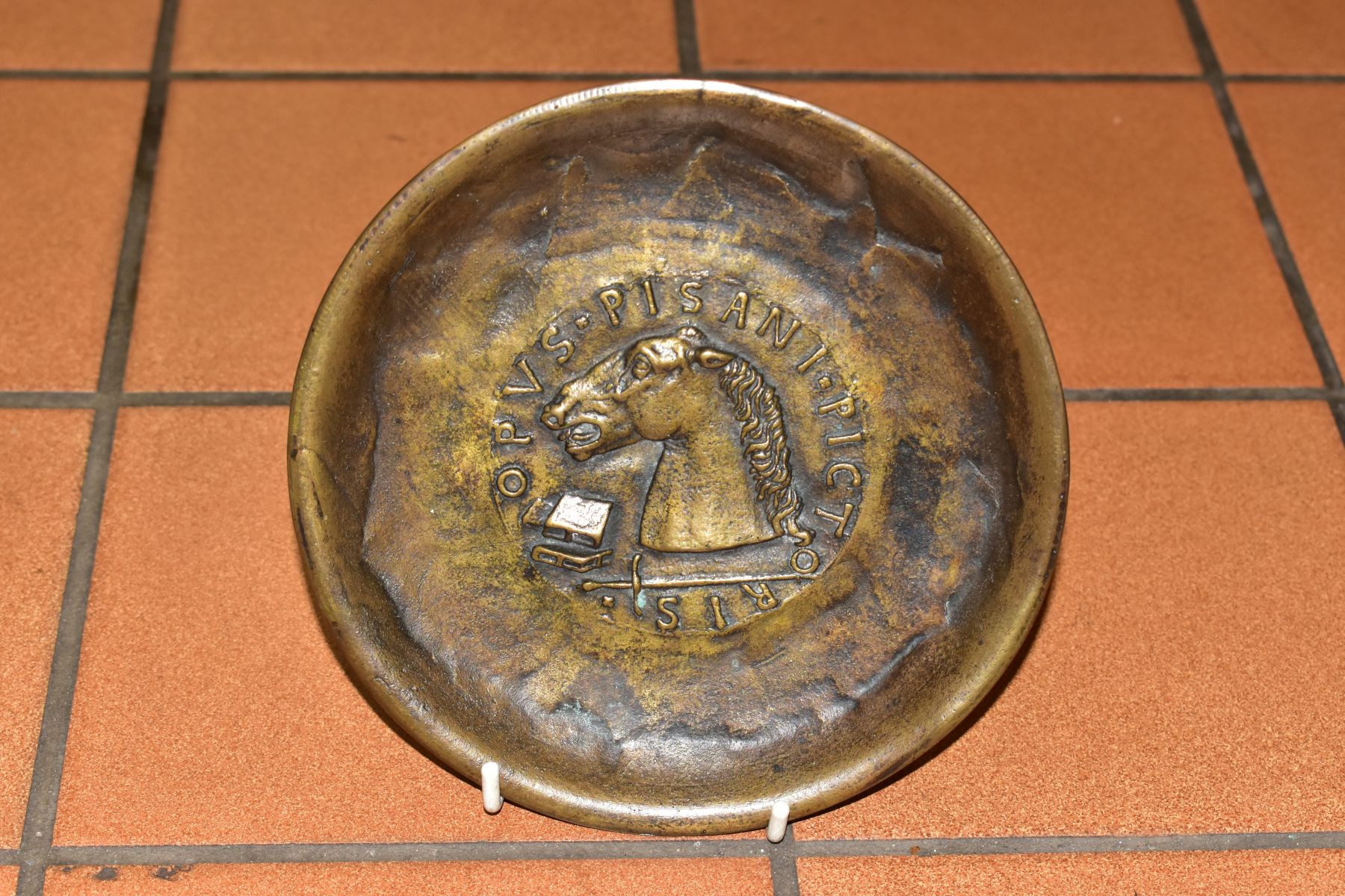 A MODERN BRONZE PLATE, after Pisanello/Pisano, the central motif depicting a horse's head, books and