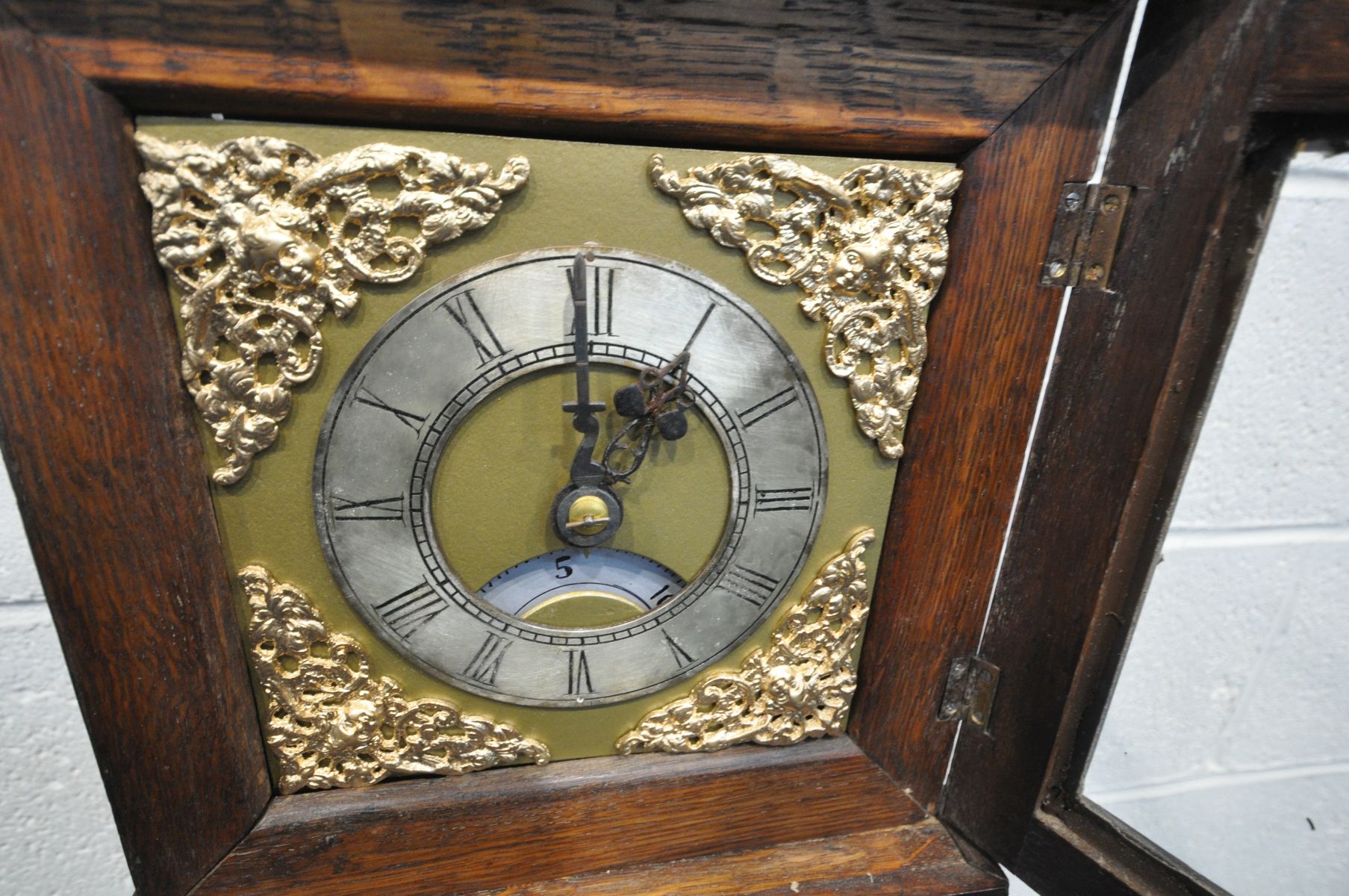 AN OAK GRANDDAUGHTER CLOCK, the square hood enclosing a brass and silvered dial, spandrels to each - Image 2 of 3