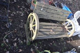 A WOODEN GARDEN BENCH with 2 modern cartwheel ends, slatted seat and back 113cm wide