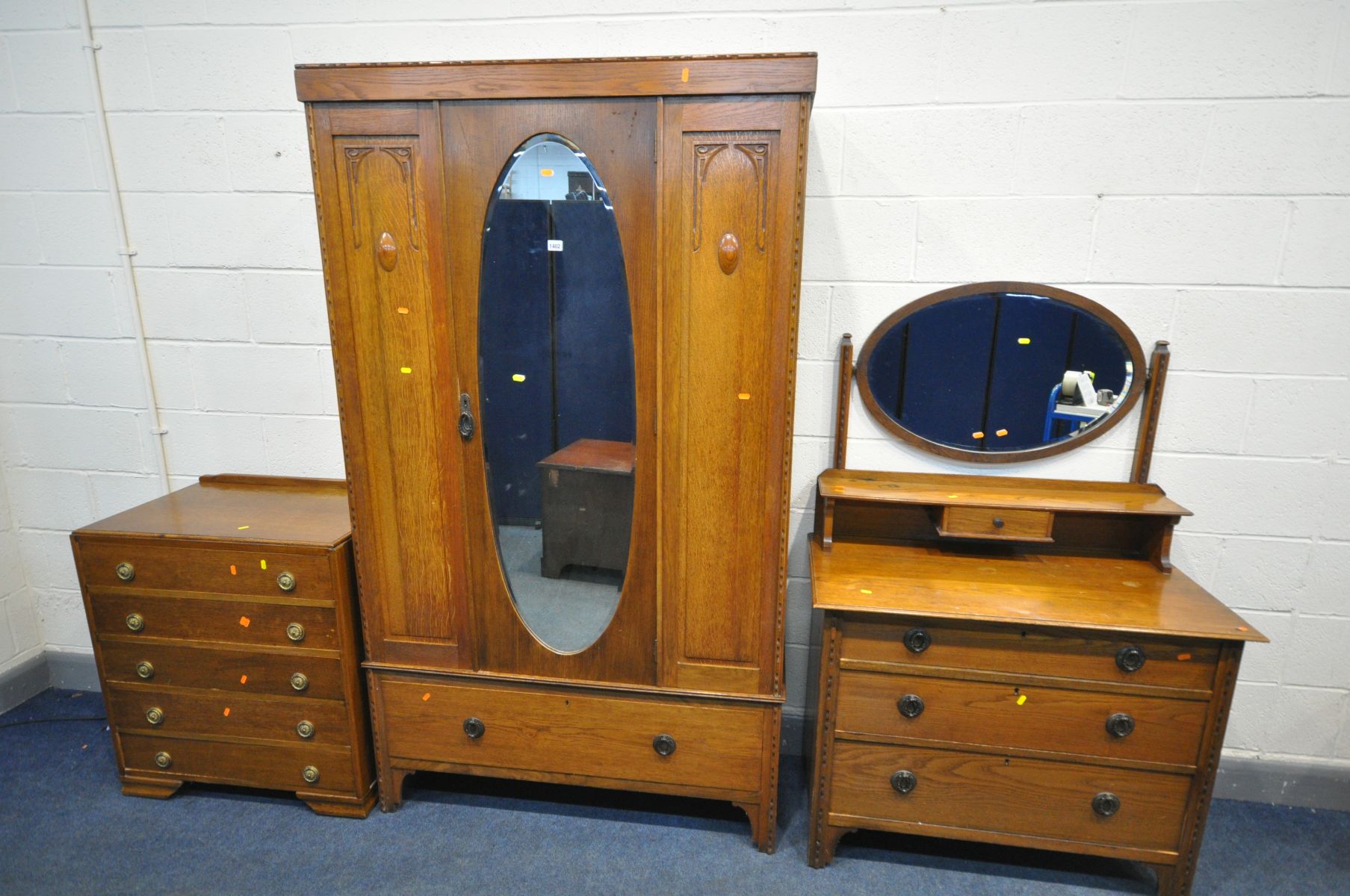 AN EARLY TO MID 20TH CENTURY OAK BEDROOM SUITE, comprising a single mirror door wardrobe, with a