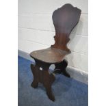 A GEORGE II AND LATER OAK HALL CHAIR, the stylised shield shaped back above shaped seat, recessed