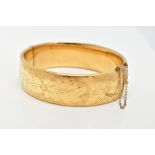 A 9CT ROLLED GOLD BANGLE, wide hinged bangle with an engraved floral pattern, approximate width 18.