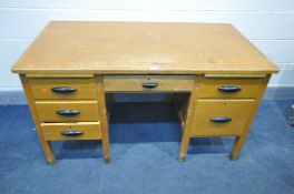AN 1940'S OAK/BEECH DESK, with two brushing slides, and five drawers, width 137cm x depth 77cm x