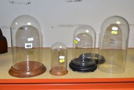 FOUR GLASS DOMES WITH WOODEN BASES comprising circular based domes of heights, excluding bases,
