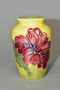 A MOORCROFT POTTERY SMALL BALUSTER VASE DECORATED WITH PINK HIBISCUS, yellow / green ground,