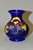 A SMALL MOORCROFT POTTERY COLUMBINE VASE, of globular form, with tubelined purple, yellow and