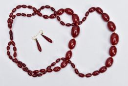 A DOUBLE STRAND CHERRY AMBER BAKERLITE BEAD NECKLACE AND EARRINGS, forty nine graduated oval