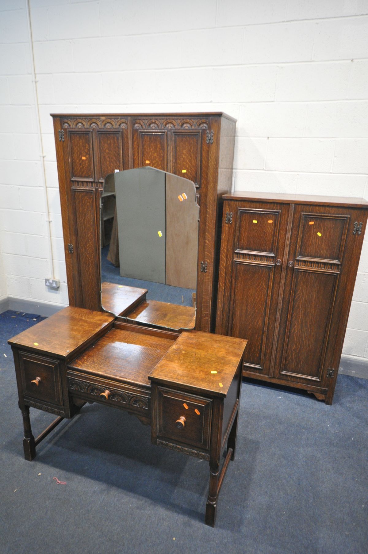 AN EARLY TO MID 20TH CENTURY OAK BEDROOM SUITE, comprising a large double door wardrobe, with key