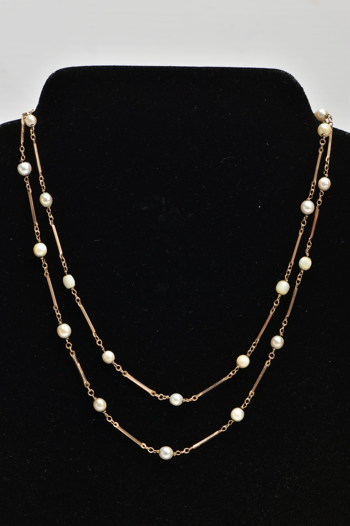 A YELLOW METAL CULTURED PEARL NECKLACE, a cultured pearl necklace interspaced with yellow metal