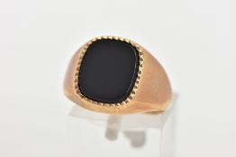 A 9CT GOLD ONYX SIGNET RING, a rounded square cut onyx set with a milgrain edge, approximate width