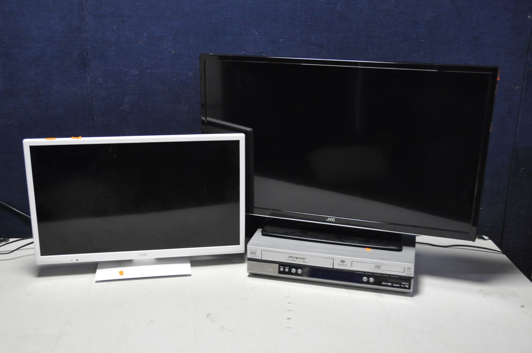 A JVC LT-32C675 32in TV along with a Logik L24HEDW15(B) 24in TV and a Panasonic NV-VP30EB-S VHS-