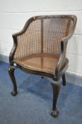 AN EARLY 20TH CENTUY MAHOGANY BERGERE ARMCHAIR, on cabriole front leg and ball and claw feet,