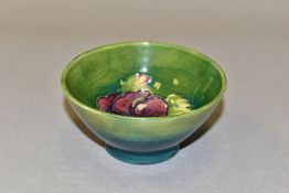 A SMALL MOORCROFT POTTERY FOOTED BOWL, decorated with tubelined purple Pansy pattern on a green/