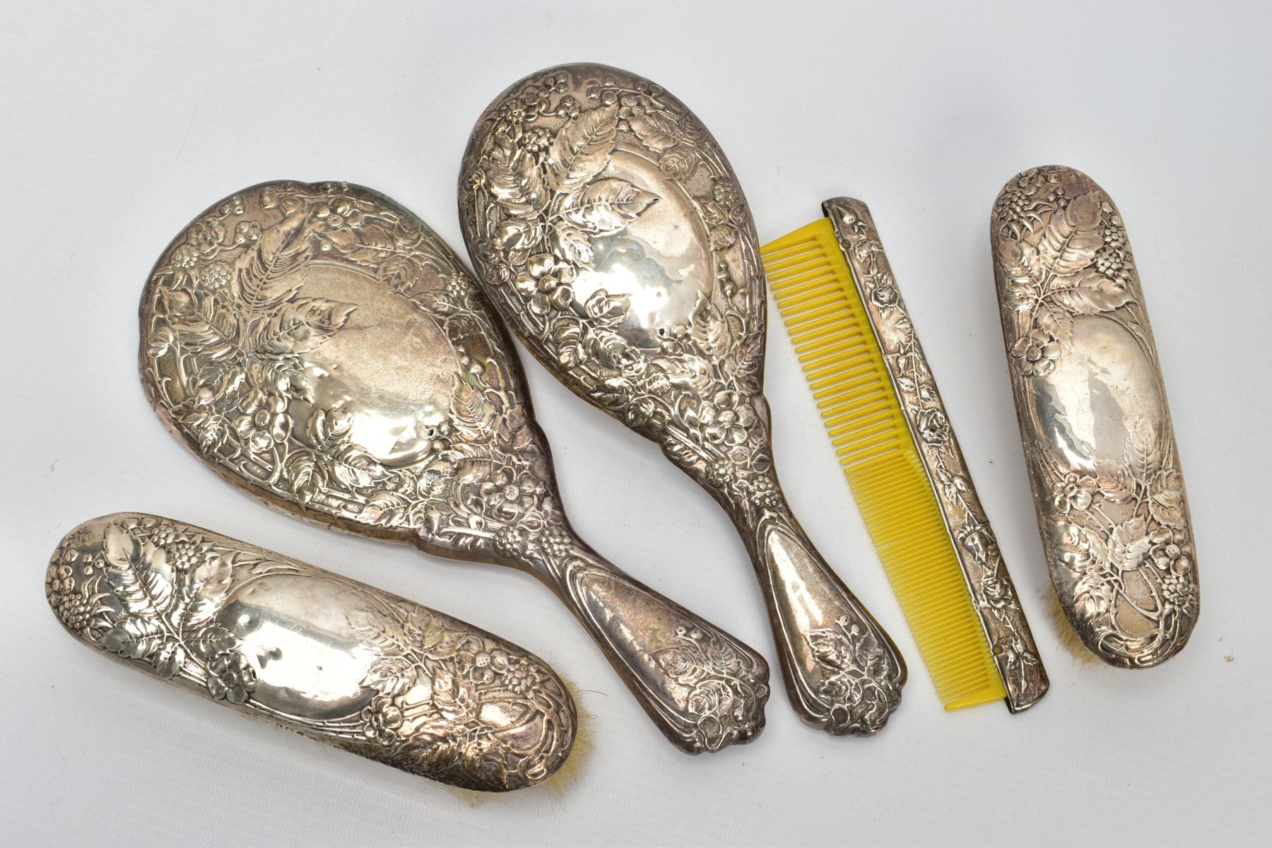 A FIVE PIECE SILVER VANITY SET, comprising of a hair brush, round hand held mirror, two clothes