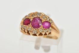 AN EARLY 20TH CENTURY DIAMOND AND RUBY RING, designed with three oval cut rubies, within a