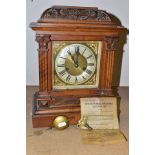 A LATE VICTORIAN CARVED OAK CASED MANTEL CLOCK OF ARCHITECTURAL FORM, the brass dial with silvered