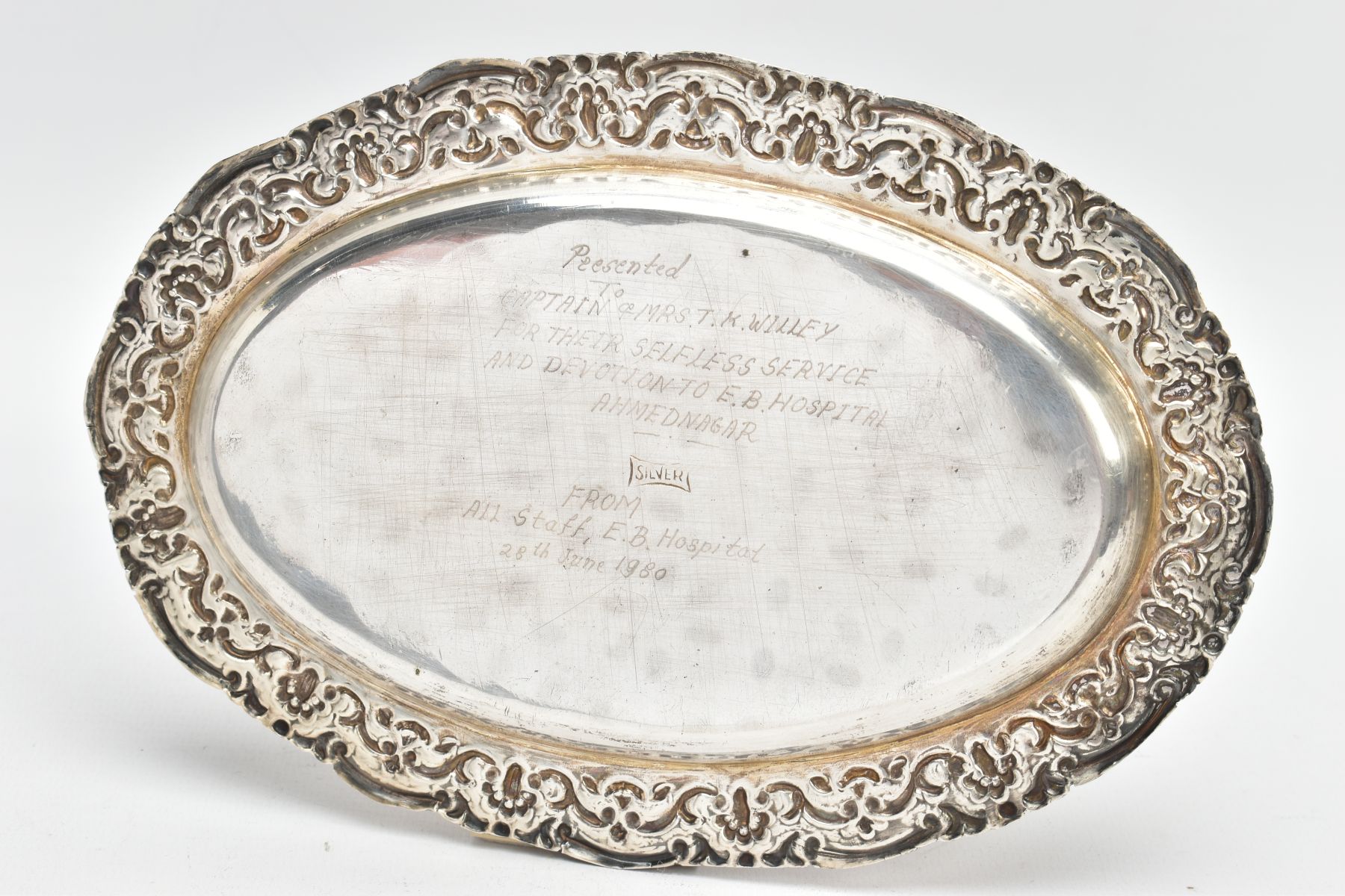 AN OVAL WHITE METAL TRAY, embossed foliate rim, engraved to the reverse of the base 'Presented to - Image 2 of 3
