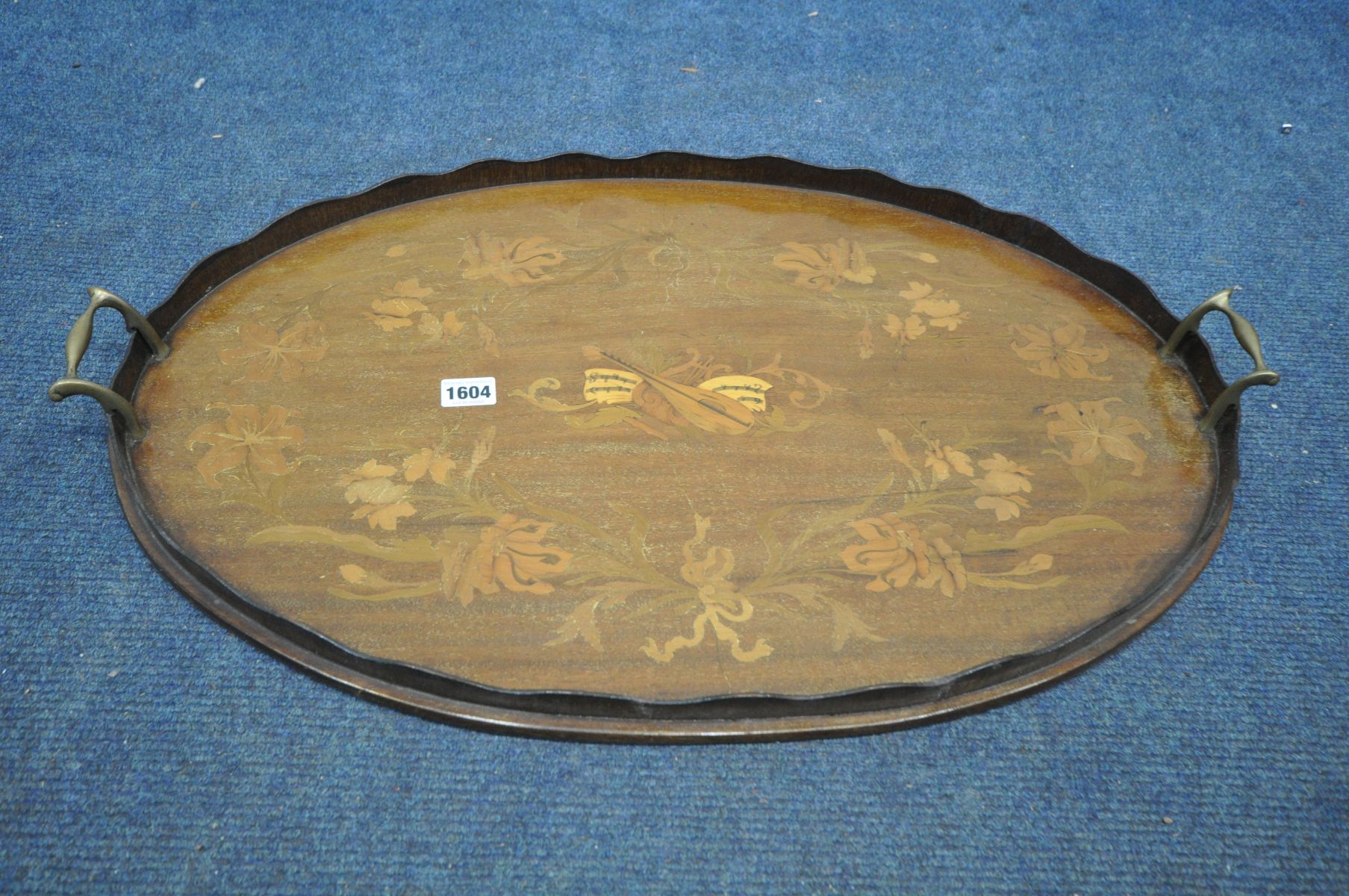 AN EDWARDIAN MAHOGANY AND MARQUETRY INLAID OVAL TRAY, with a wavy gallery and twin brass handles,